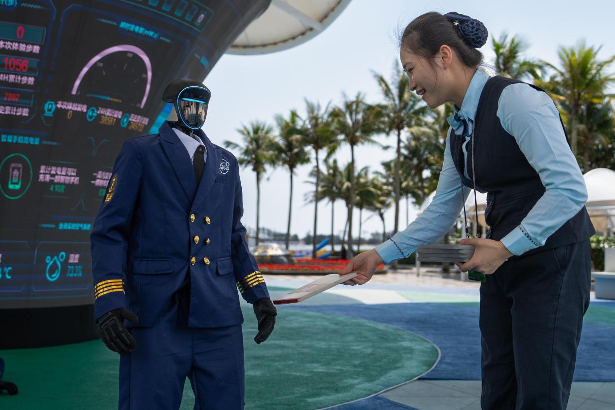 邮政工作人员与服务博鳌年会现场的智能机器人互动(陈师摄)