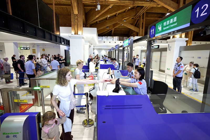執勤民警為入境旅客辦理邊檢手續。蒙緒順攝