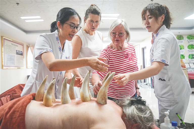4月3日，外国游客在三亚国际友好中医疗养院体验学习海南黎医牛角拔罐技术。