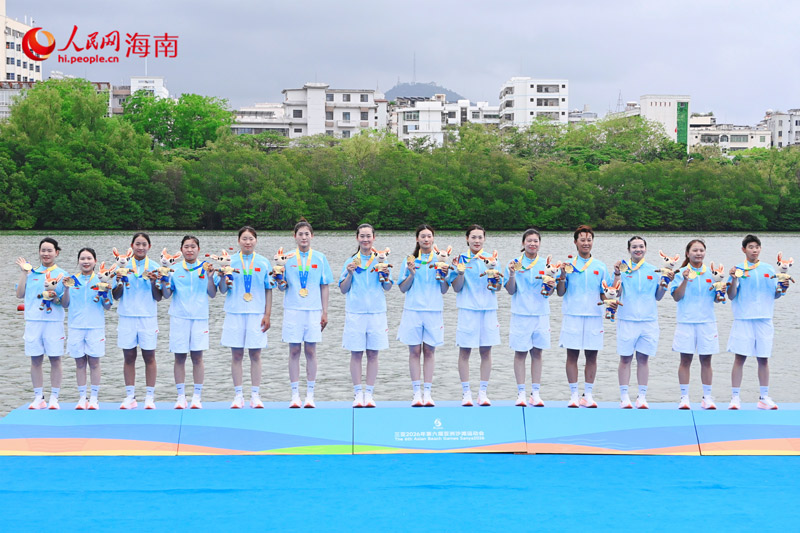 中国队首次问鼎亚沙会龙舟女子 100 米直道赛，队员们手捧金牌与亚沙会吉祥物合影留念。人民网实习生马宁紫摄。