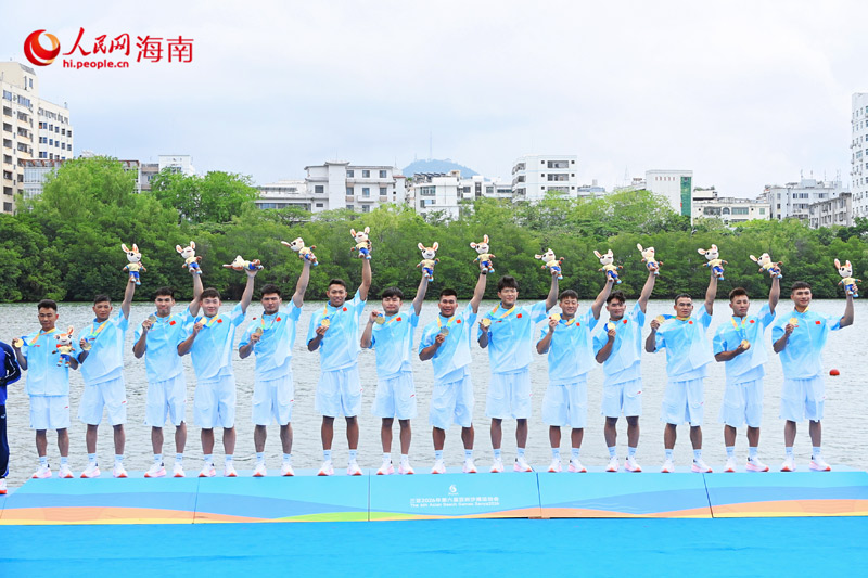 中国男队队员手捧金牌与吉祥物，庆祝亚沙会龙舟项目历史首金。实习生马宁紫摄