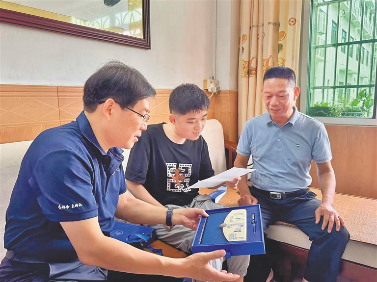 中国科学技术大学海南招生组组长（左）张家海向石家铭（中）赠送伴手礼。海南日报全媒体记者 王子豪 摄