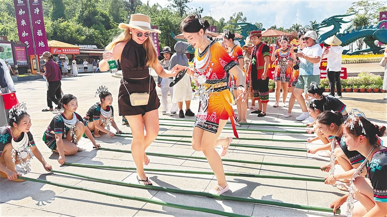  10月1日，外國游客在三亞南山文化旅游區體驗非遺竹竿舞。新華社發