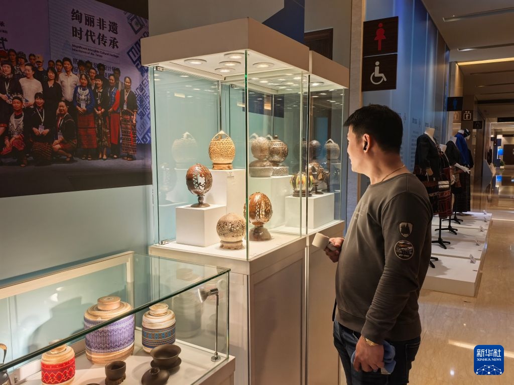 10月3日，菲律賓游客在海南非物質文化遺產主題展上參觀椰雕展品。新華社記者 馬欣然 攝