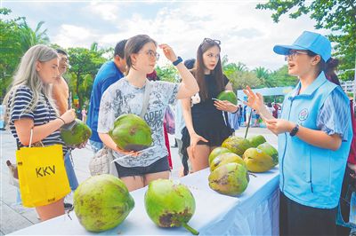 5月1日，三亚大东海旅游区，志愿者为游客免费发放椰子。
